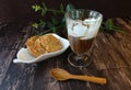 Affogato, a scoop of vanillaÃÂ ice cream in a glass of espresso served with peanut cookies in dark background